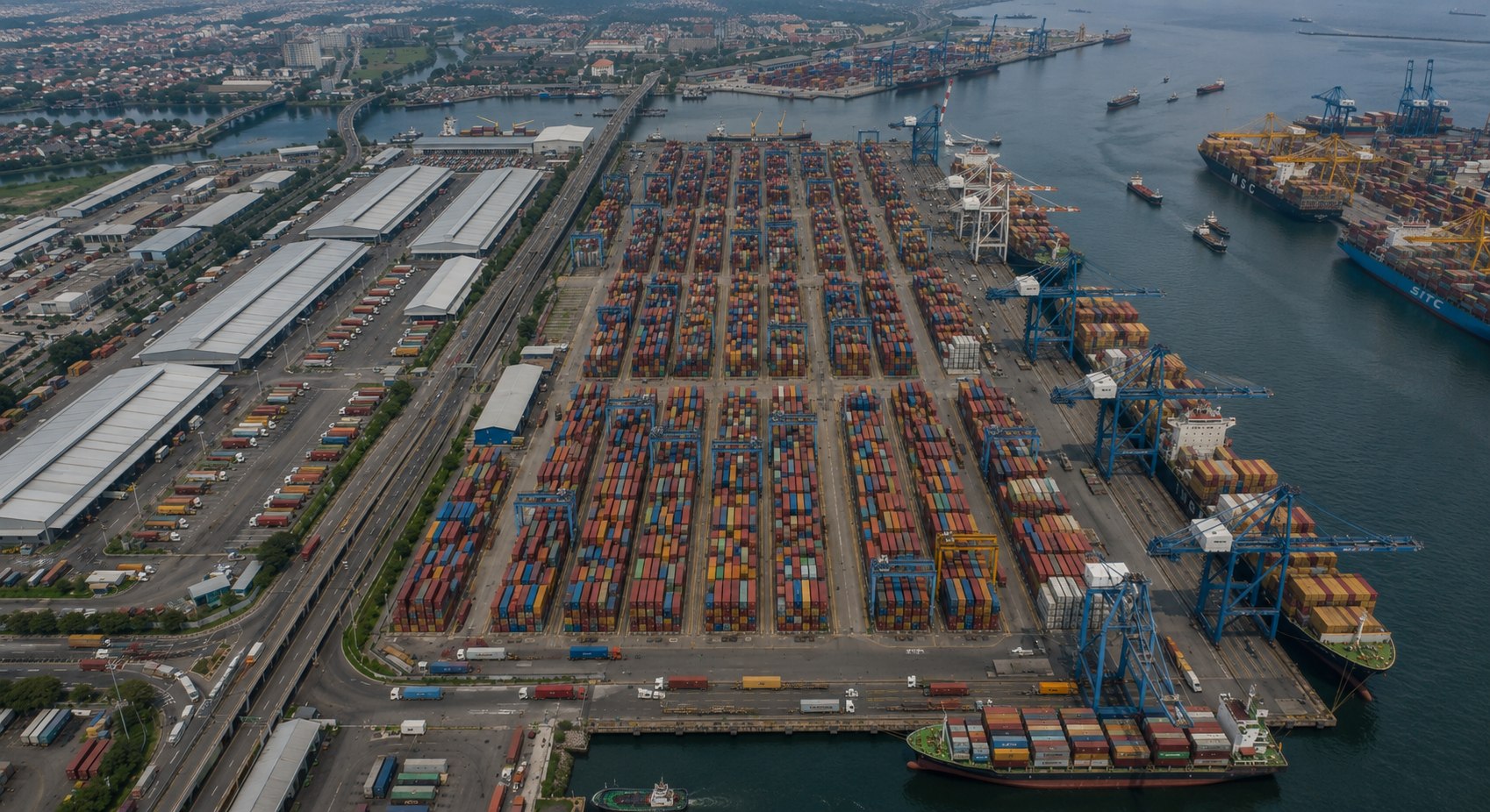 Aerial view of an Indonesian container port with stacked freight containers and ship-to-shore cranes, infrastructure and trade sector careers at Majapahit Group